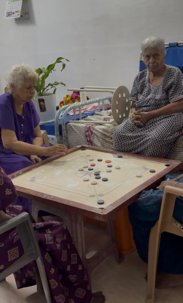 Elderly residents enjoying a group carrom activity